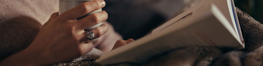 Woman reading a book on a sofa
